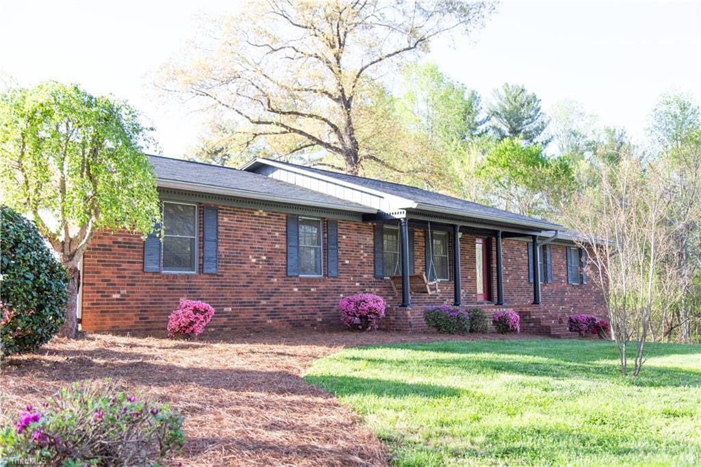 single story home with a front yard and brick siding