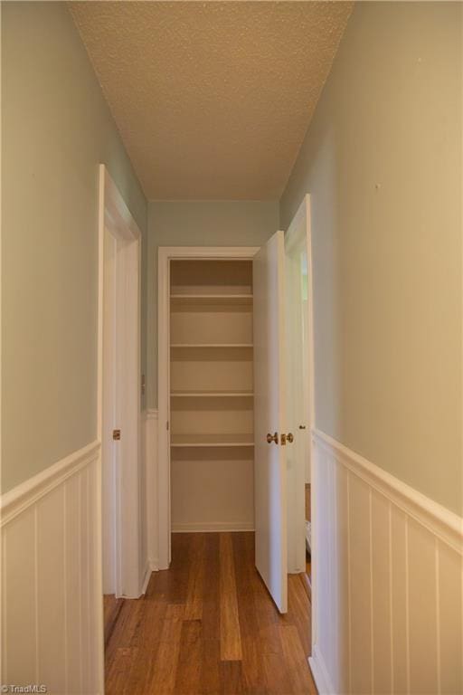 159 Evans Ln, Wilkesboro, NC 28697 - hallway featuring a decorative wall, wainscoting, a textured ceiling, and wood finished floors