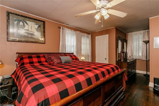 bedroom featuring ceiling fan, ornamental molding, and dark wood-type flooring