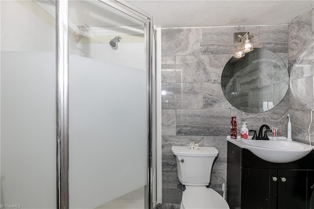 bathroom featuring walk in shower, vanity, toilet, and tile walls