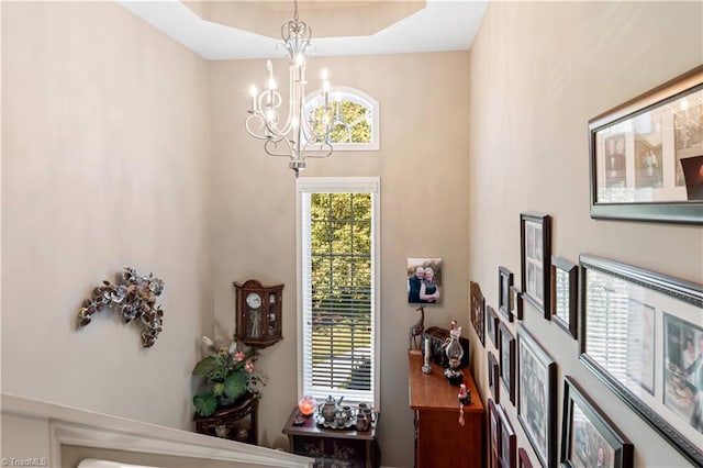 foyer with a notable chandelier and a raised ceiling