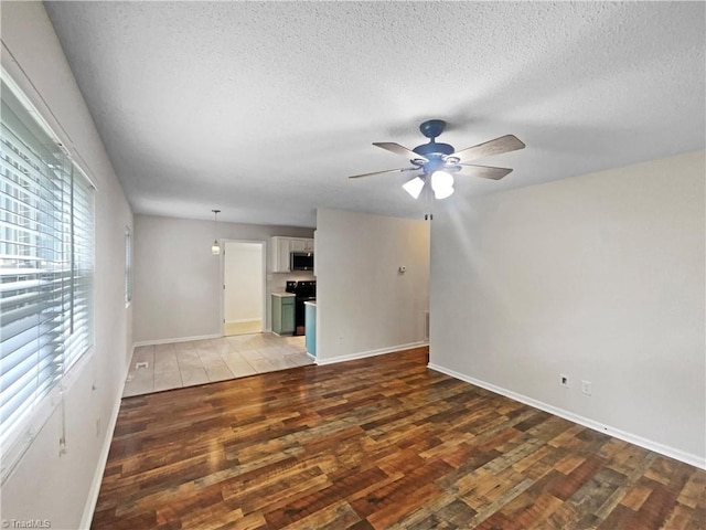 310 Cole St, Thomasville, NC 27360 - unfurnished living room featuring wood finished floors, a ceiling fan, and a textured ceiling