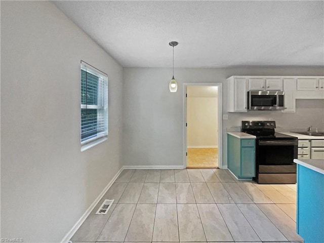 310 Cole St, Thomasville, NC 27360 - kitchen with appliances with stainless steel finishes, light countertops, a textured ceiling, white cabinets, and pendant lighting