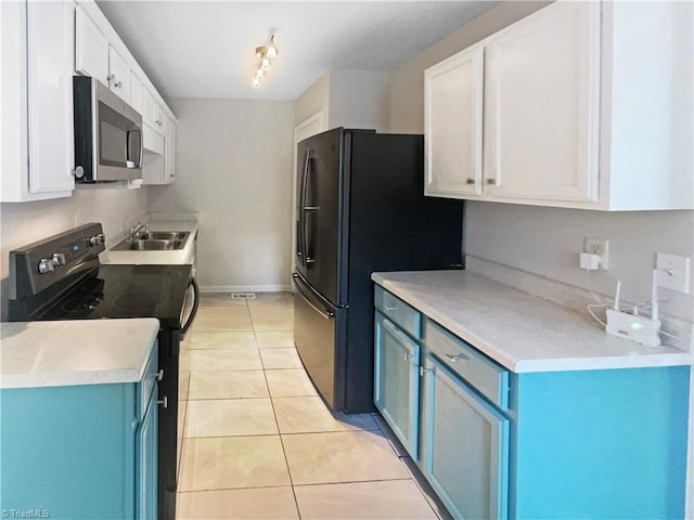 310 Cole St, Thomasville, NC 27360 - kitchen featuring black appliances, blue cabinets, light tile patterned floors, white cabinetry, and light countertops