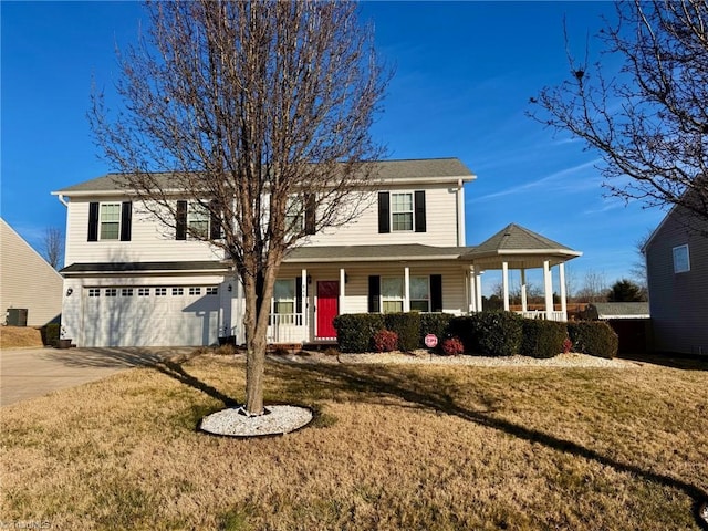 view of front of house with a garage, covered porch, and a front yard