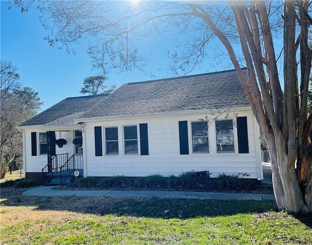 view of front of property with a front yard and roof with shingles