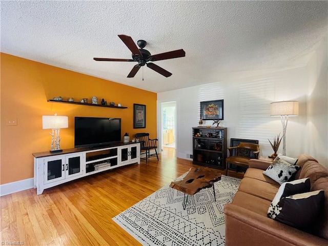 living room with a textured ceiling, wood finished floors, and a ceiling fan