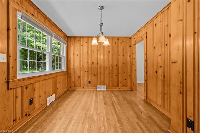 465 NC Highway 42 S, Asheboro, NC 27205 - unfurnished dining area featuring light wood-style floors, baseboards, a chandelier, and wooden walls