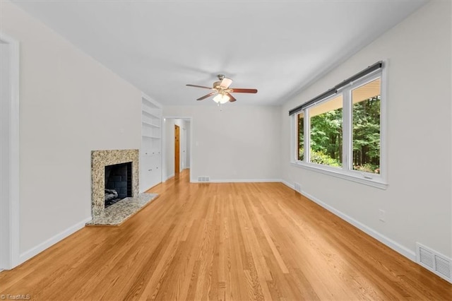 465 NC Highway 42 S, Asheboro, NC 27205 - unfurnished living room with built in shelves, baseboards, light wood-type flooring, and a ceiling fan