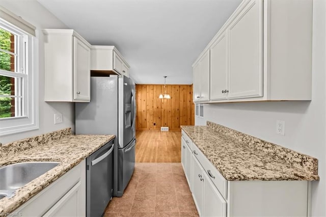 465 NC Highway 42 S, Asheboro, NC 27205 - kitchen with stainless steel appliances, wood walls, white cabinetry, light stone countertops, and hanging light fixtures