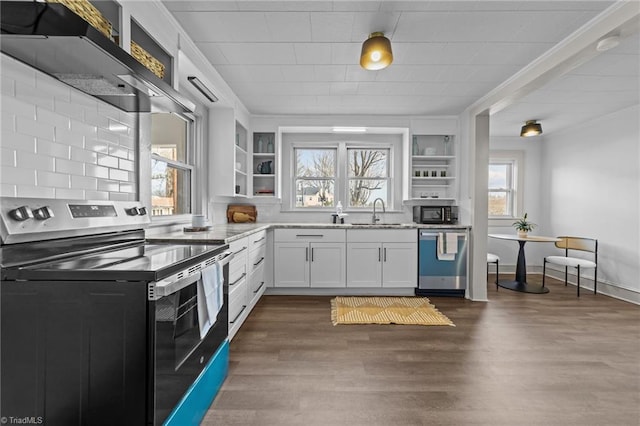 kitchen with stainless steel appliances, dark wood-type flooring, a sink, light stone countertops, and open shelves