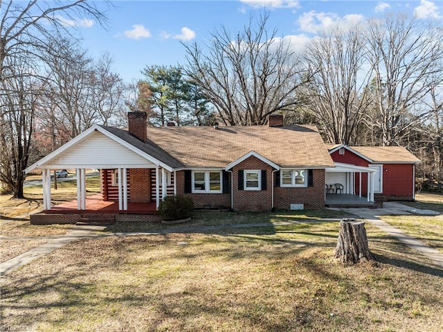 view of front of property featuring covered porch, a chimney, a front lawn, and brick siding