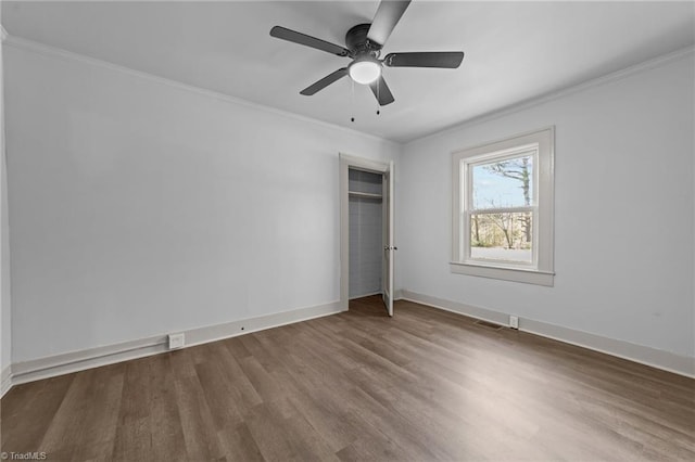 unfurnished bedroom with ornamental molding, dark wood-type flooring, visible vents, and baseboards