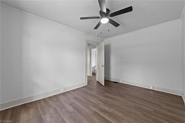 unfurnished room with visible vents, crown molding, baseboards, and wood finished floors