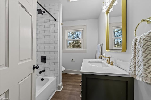 full bathroom with a healthy amount of sunlight, vanity, toilet, and wood finished floors