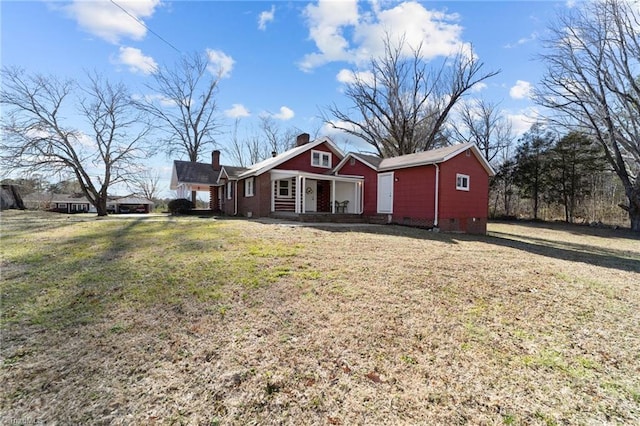 view of front facade with a chimney and a front lawn