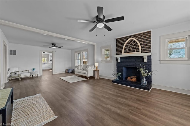 unfurnished living room with a wealth of natural light, a fireplace, wood finished floors, and visible vents