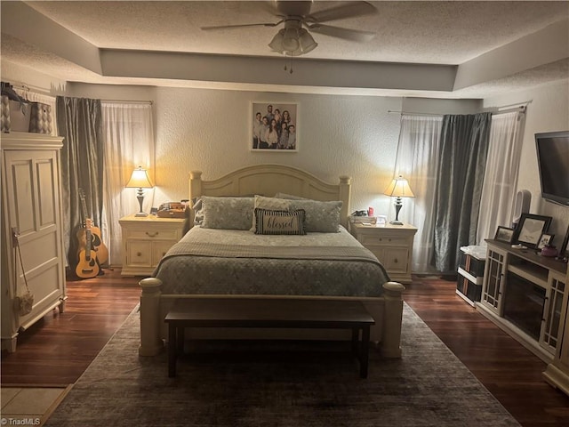 bedroom featuring dark wood-type flooring, ceiling fan, and a textured ceiling