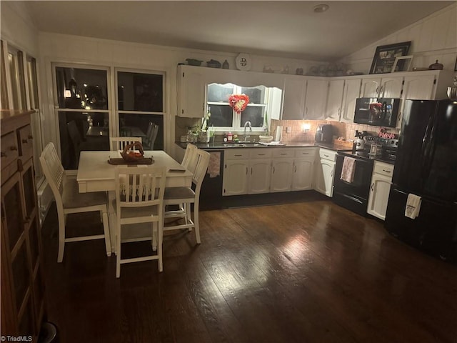 kitchen with vaulted ceiling, sink, white cabinets, dark hardwood / wood-style flooring, and black appliances