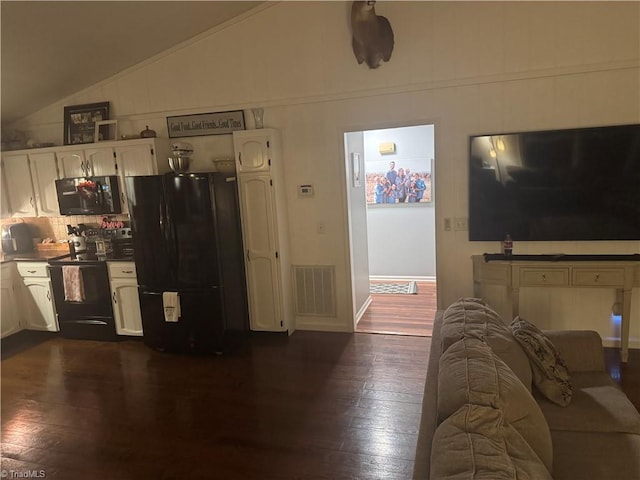 kitchen with dark hardwood / wood-style flooring, white cabinetry, vaulted ceiling, and black appliances