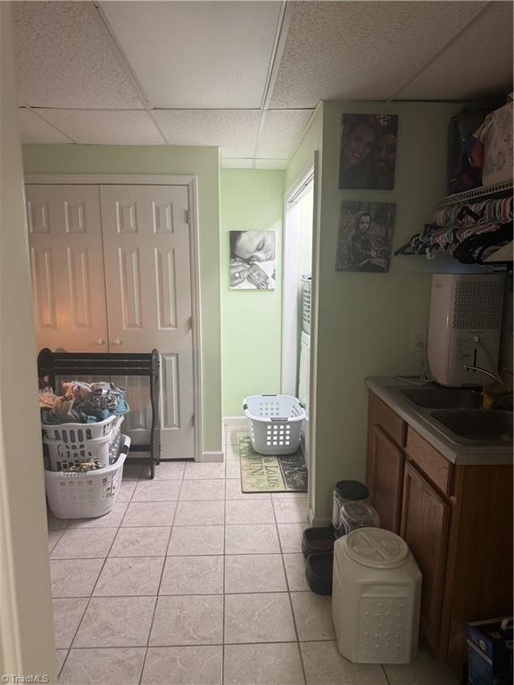 bathroom featuring tile patterned flooring, vanity, and a drop ceiling