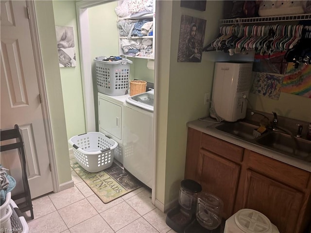 laundry room featuring sink, light tile patterned floors, and washing machine and clothes dryer