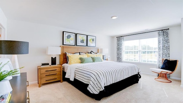 bedroom with light colored carpet and baseboards