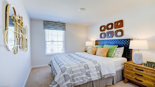 bedroom featuring light colored carpet and baseboards