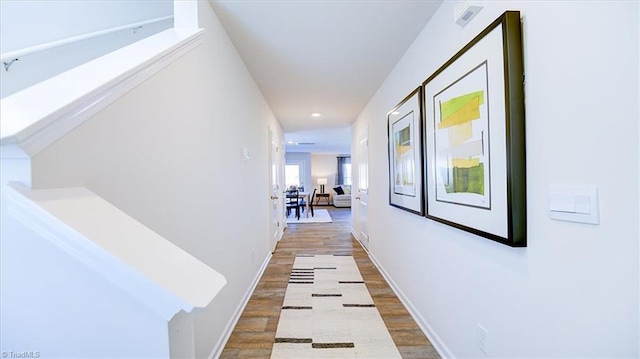 hall with baseboards and wood finished floors
