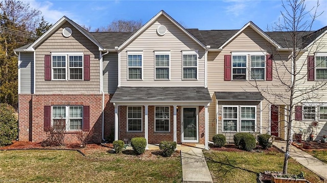 view of property with brick siding and a front yard