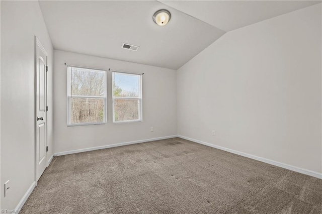 spare room with baseboards, visible vents, vaulted ceiling, and carpet flooring