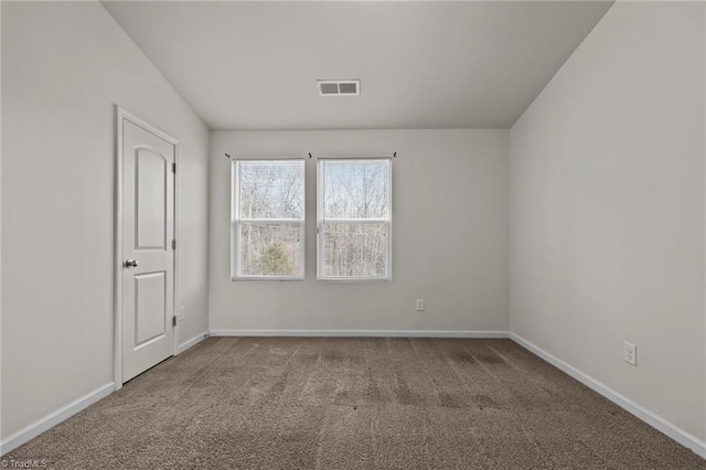 empty room featuring carpet, visible vents, and baseboards