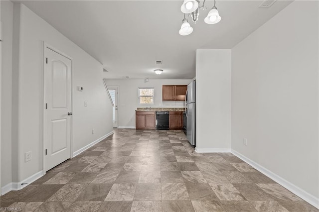 kitchen featuring black dishwasher, baseboards, brown cabinetry, freestanding refrigerator, and light countertops