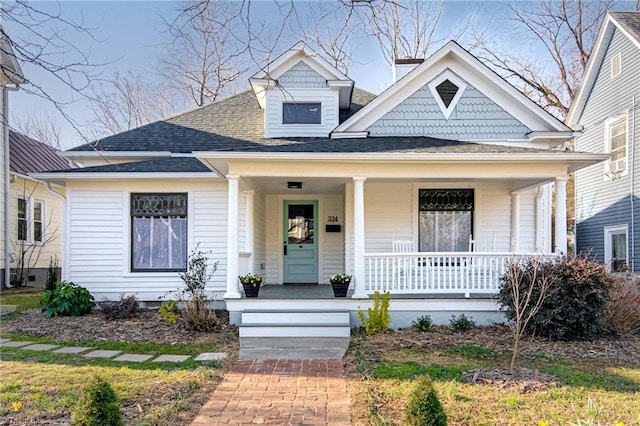 view of front facade with roof with shingles and covered porch