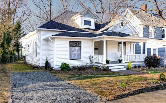 view of front of house with roof with shingles and covered porch