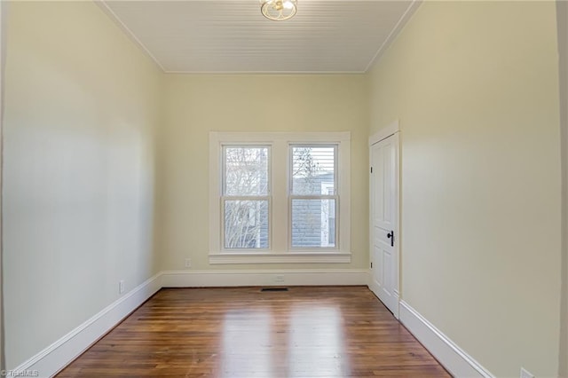 unfurnished room with baseboards, wood finished floors, and ornamental molding