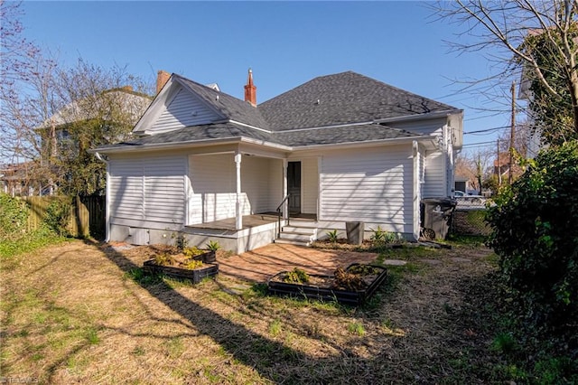 rear view of property featuring a yard and fence