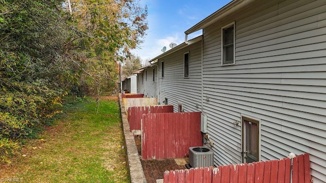 view of home's exterior with a yard and central air condition unit