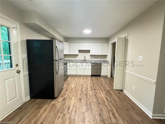 kitchen featuring light hardwood / wood-style floors, sink, white cabinetry, and stainless steel appliances