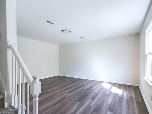 spare room with dark hardwood / wood-style floors and plenty of natural light