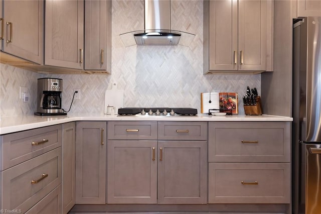 4166 Lytchfield Ct, Winston-Salem, NC 27104 - kitchen featuring wall chimney exhaust hood, freestanding refrigerator, gray cabinetry, cooktop, and tasteful backsplash
