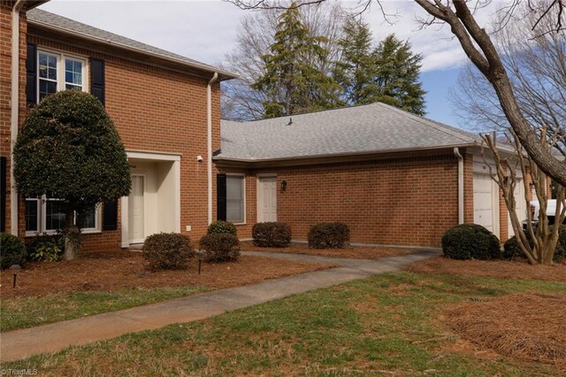 4166 Lytchfield Ct, Winston-Salem, NC 27104 - back of house with brick siding, a garage, and roof with shingles