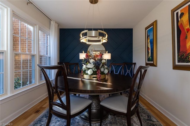 4166 Lytchfield Ct, Winston-Salem, NC 27104 - dining space featuring a chandelier, wood finished floors, and baseboards