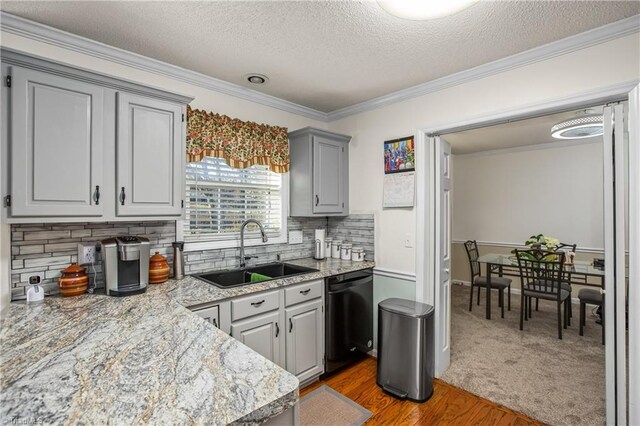 kitchen with sink, gray cabinetry, wood-type flooring, ornamental molding, and dishwasher