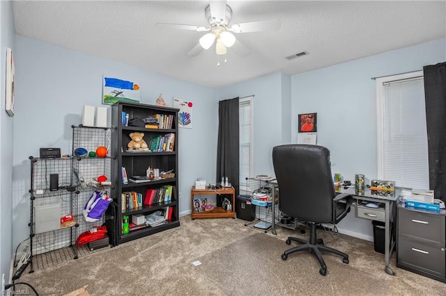 carpeted office featuring ceiling fan and a textured ceiling