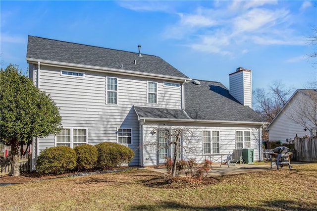 rear view of property with a yard and a patio area