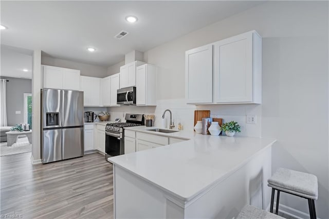 1868 Autumn Mist Dr, Winston-Salem, NC 27103 - kitchen with appliances with stainless steel finishes, light countertops, a peninsula, decorative backsplash, and white cabinetry