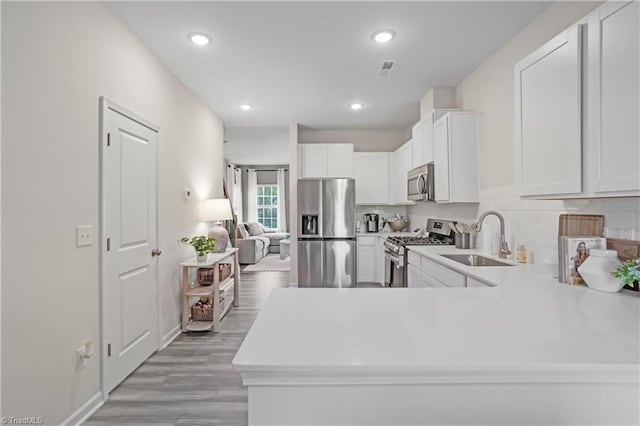 1868 Autumn Mist Dr, Winston-Salem, NC 27103 - kitchen featuring stainless steel appliances, light countertops, light wood-style floors, white cabinets, and recessed lighting