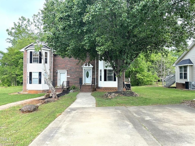 208 Mallard Creek Dr, Graham, NC 27253 - view of front facade with central AC, brick siding, and a front lawn