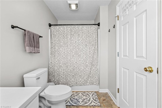 bathroom with vanity, curtained shower, toilet, and a textured ceiling